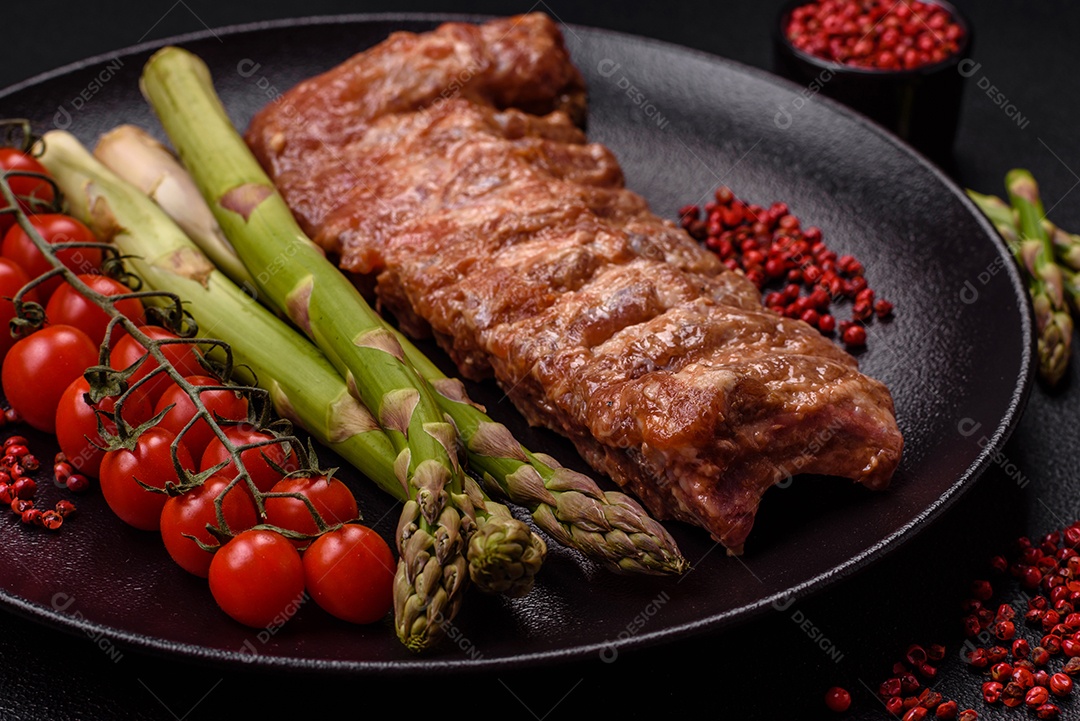 Costelas de porco cruas marinadas com sal, especiarias e ervas sobre um fundo escuro de concreto
