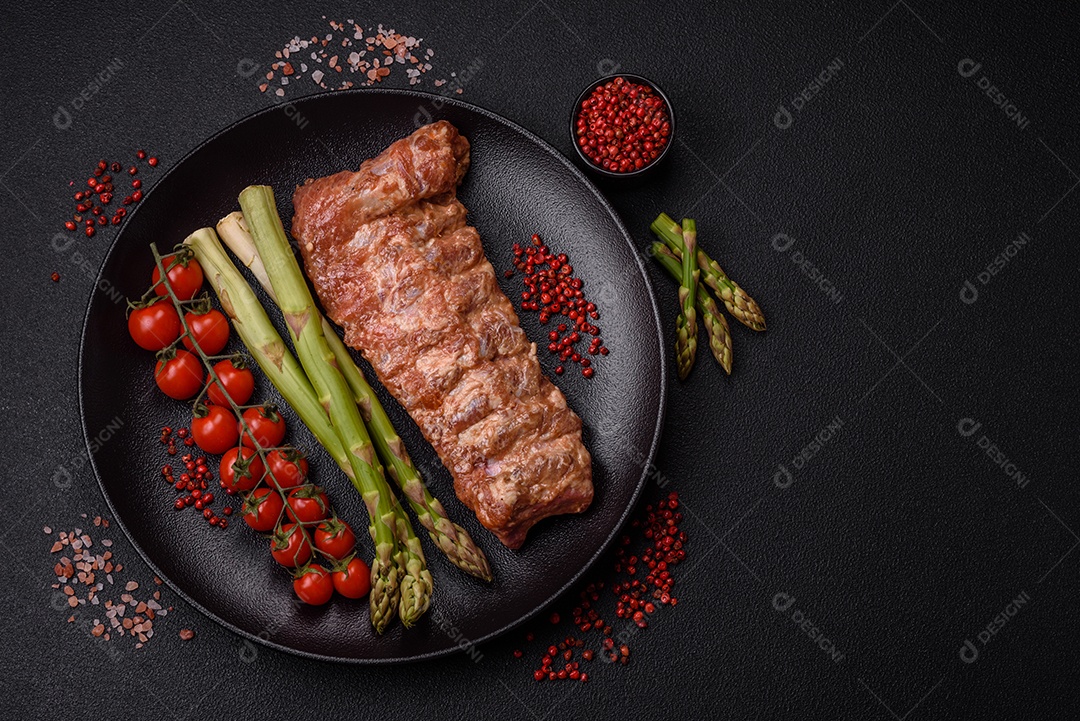 Filé de frango cru com sal, especiarias e ervas sobre um fundo escuro de concreto