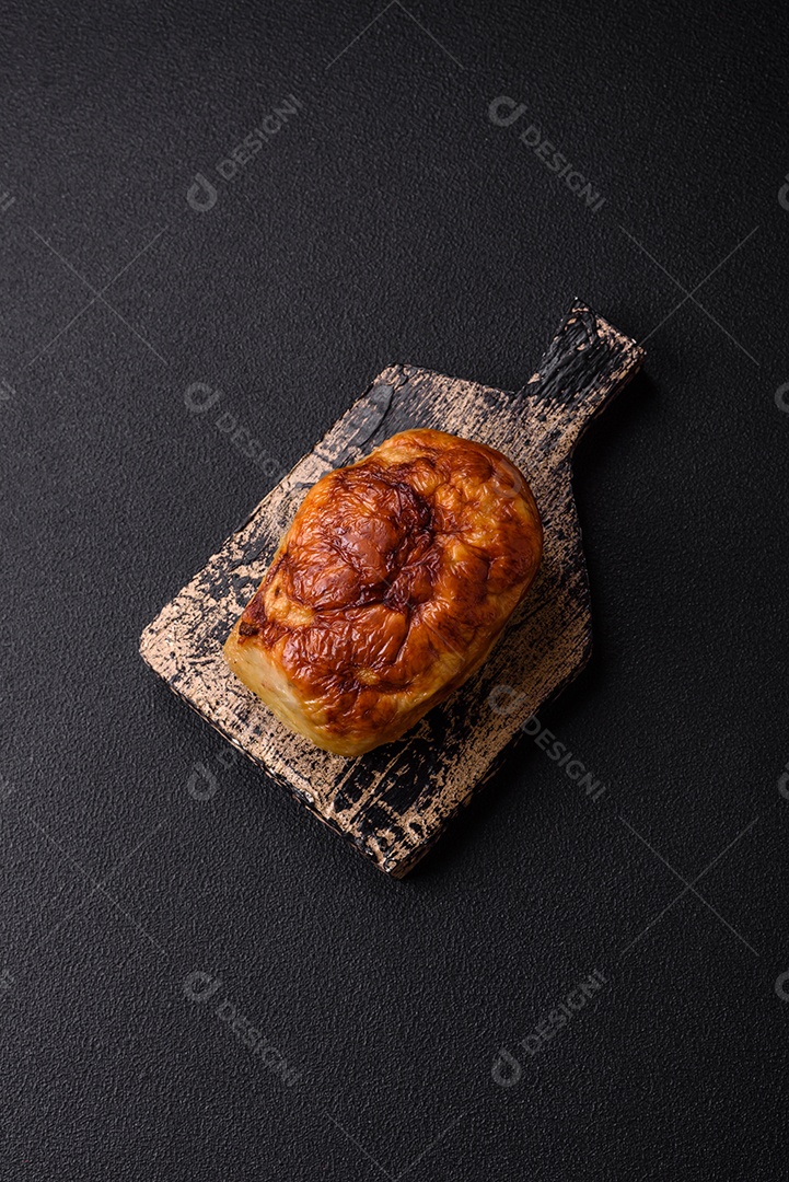 Rolo delicioso ou linguiça de frango picada caseira com sal, especiarias e ervas sobre um fundo escuro de concreto