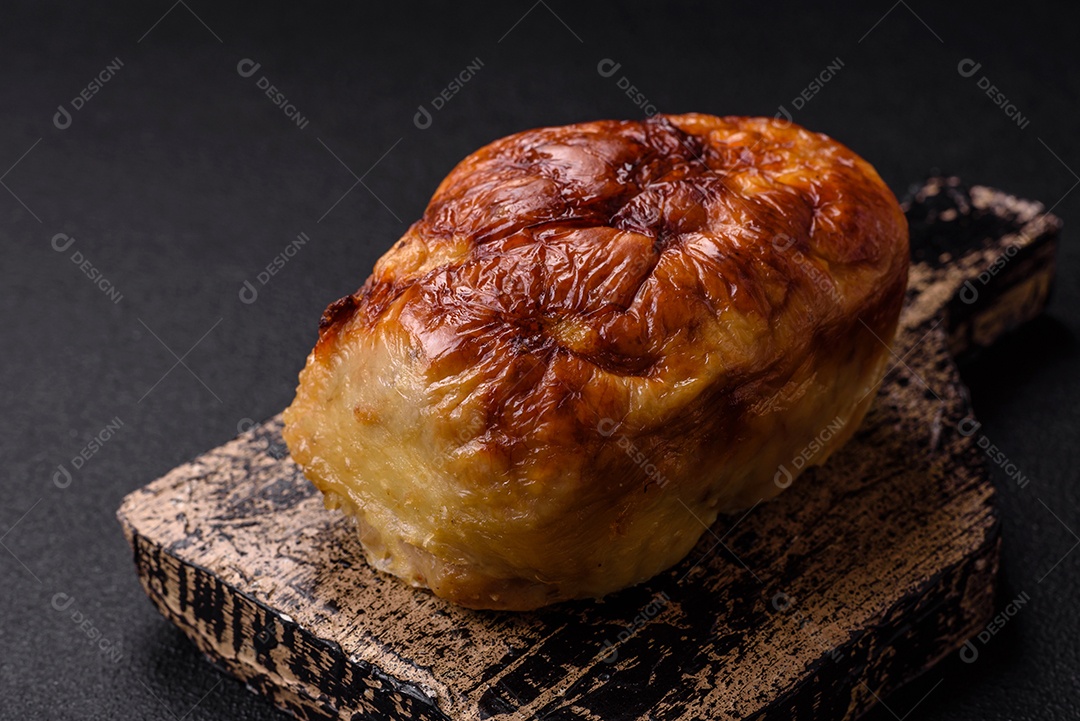 Rolo delicioso ou linguiça de frango picada caseira com sal, especiarias e ervas sobre um fundo escuro de concreto