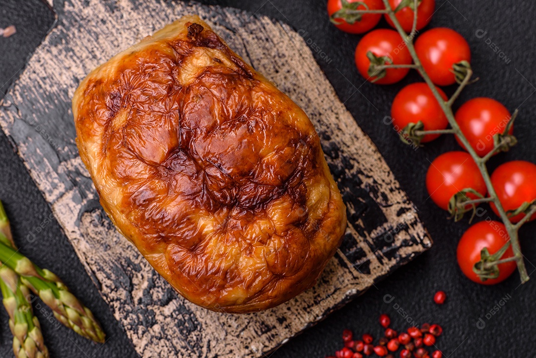 Rolo delicioso ou linguiça de frango picada caseira com sal, especiarias e ervas sobre um fundo escuro de concreto