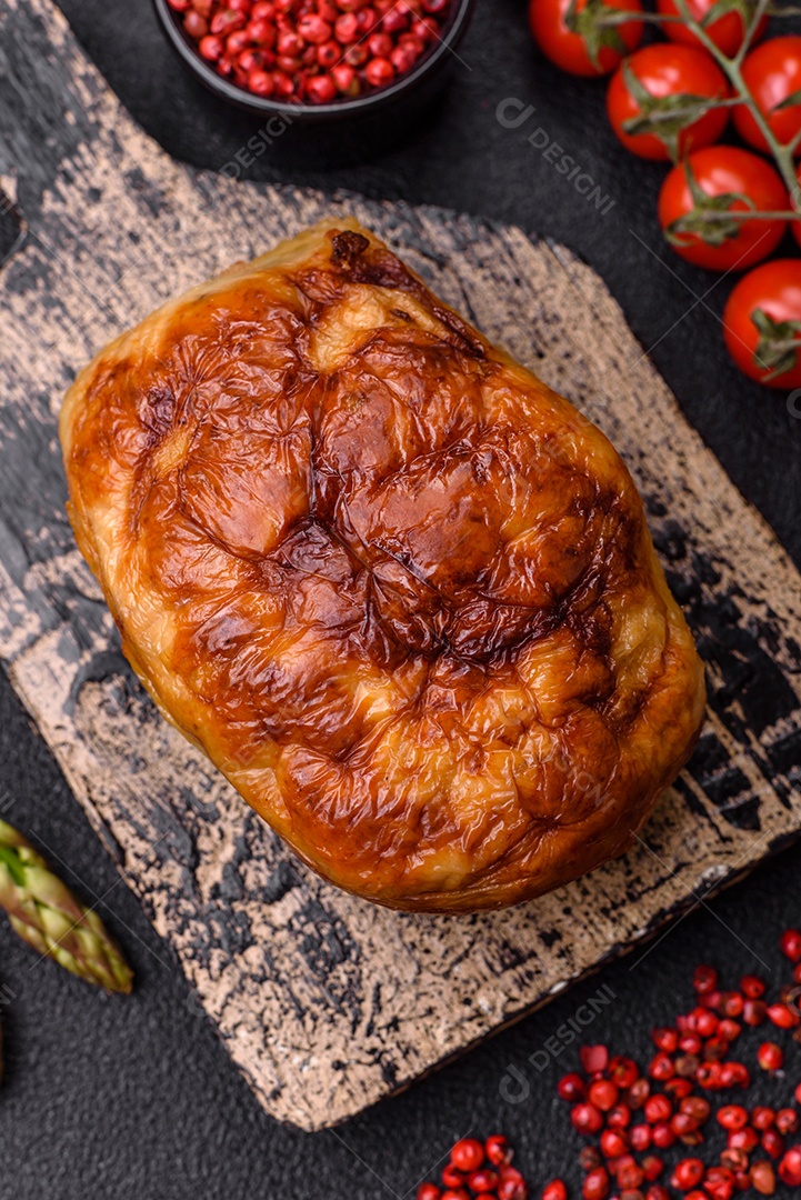 Rolo delicioso ou linguiça de frango picada caseira com sal, especiarias e ervas sobre um fundo escuro de concreto