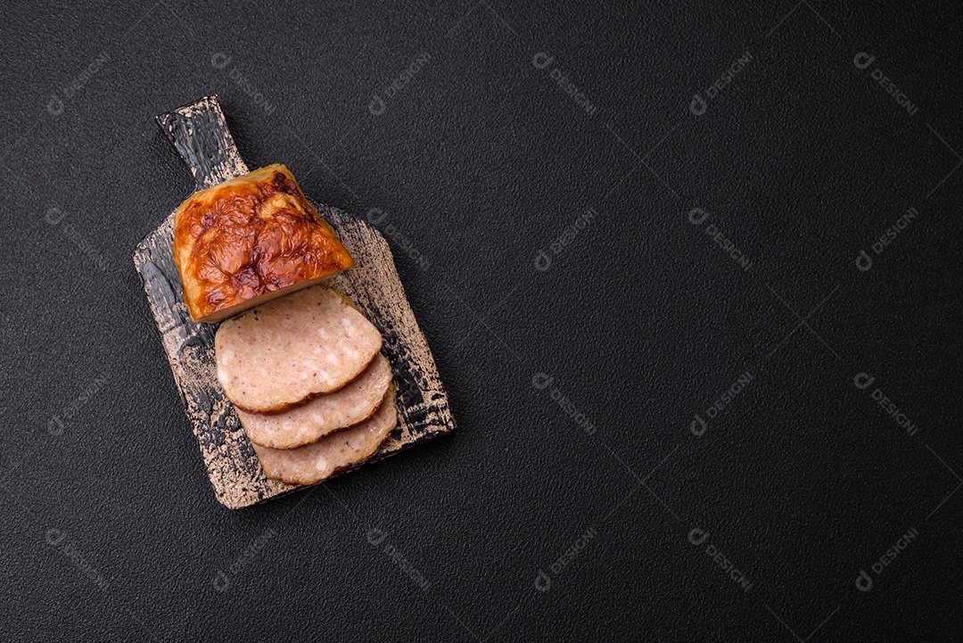 Rolo delicioso ou linguiça de frango picada caseira com sal, especiarias e ervas sobre um fundo escuro de concreto