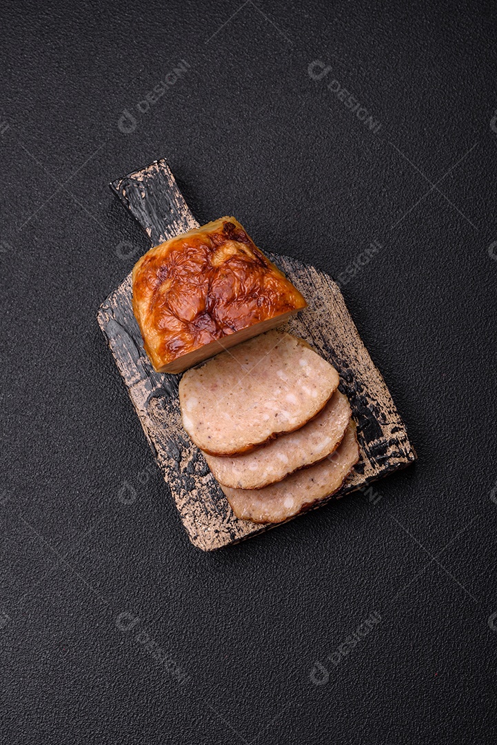 Rolo delicioso ou linguiça de frango picada caseira com sal, especiarias e ervas sobre um fundo escuro de concreto