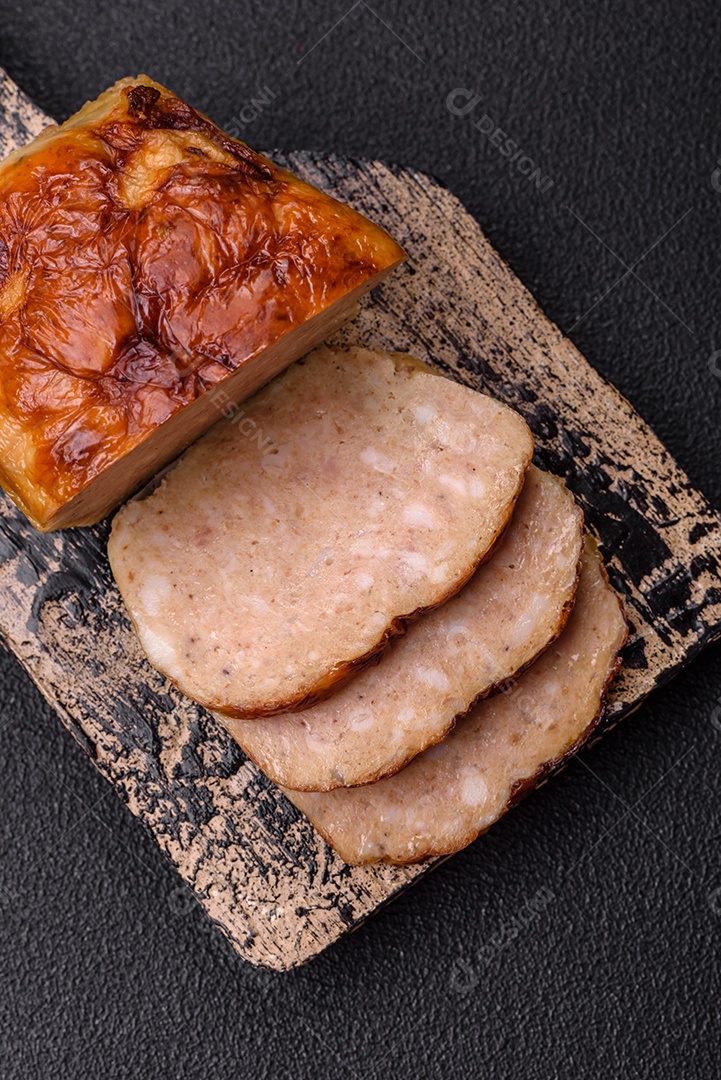 Rolo delicioso ou linguiça de frango picada caseira com sal, especiarias e ervas sobre um fundo escuro de concreto