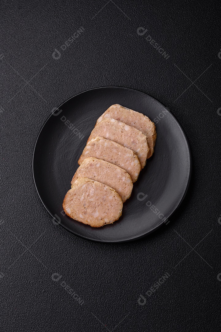 Rolo delicioso ou linguiça de frango picada caseira com sal, especiarias e ervas sobre um fundo escuro de concreto