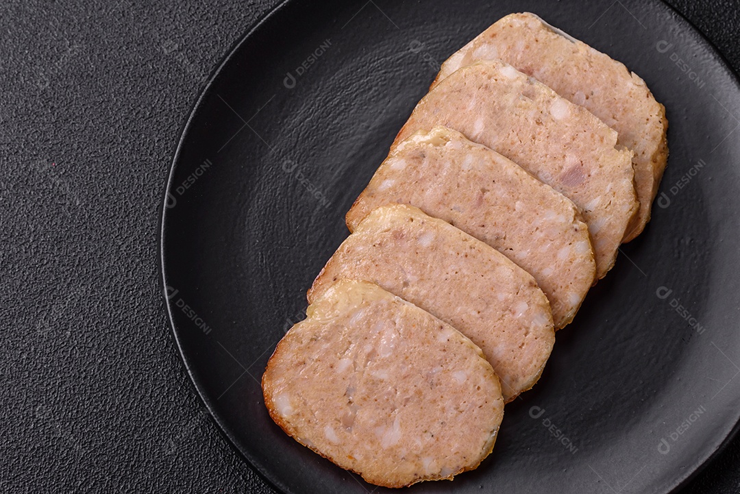 Rolo delicioso ou linguiça de frango picada caseira com sal, especiarias e ervas sobre um fundo escuro de concreto