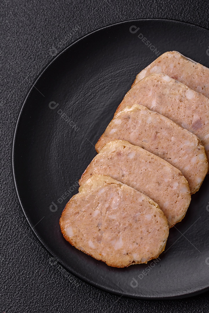 Rolo delicioso ou linguiça de frango picada caseira com sal, especiarias e ervas sobre um fundo escuro de concreto