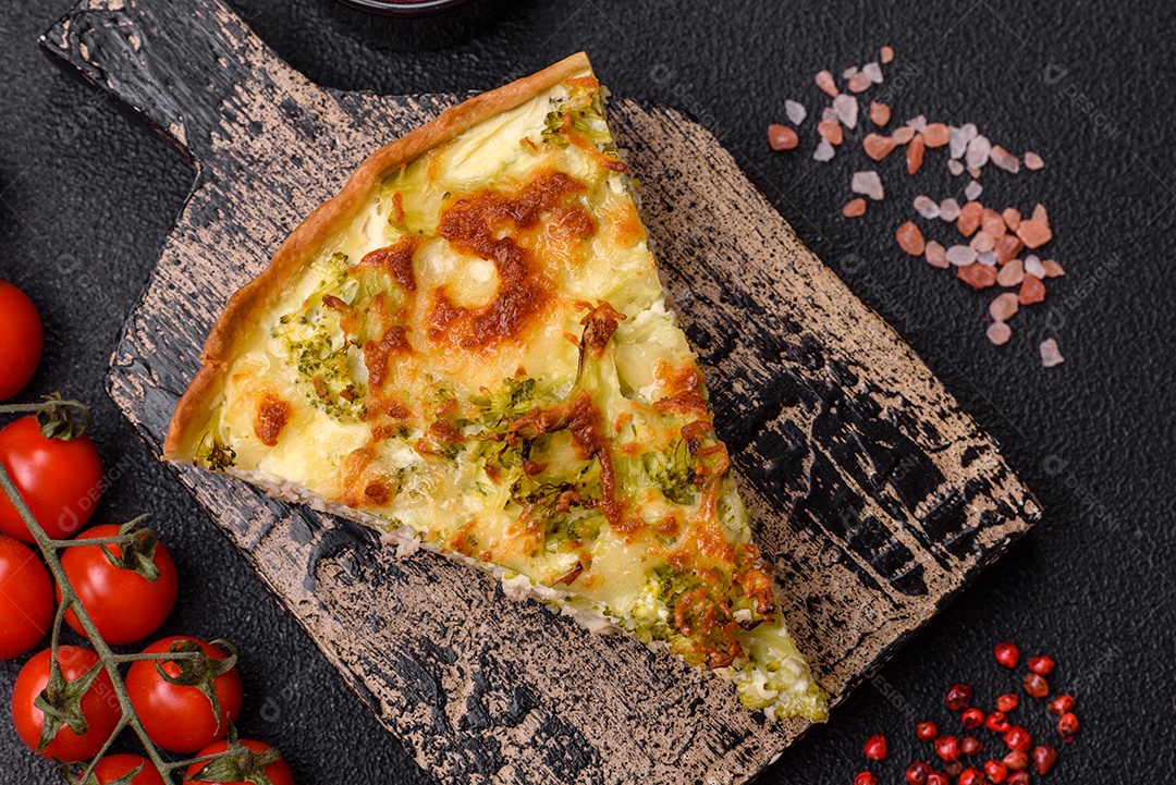 Deliciosa quiche com brócolis, queijo, frango, especiarias e ervas sobre um fundo escuro de concreto
