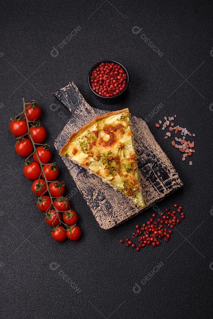 Deliciosa quiche com brócolis, queijo, frango, especiarias e ervas sobre um fundo escuro de concreto