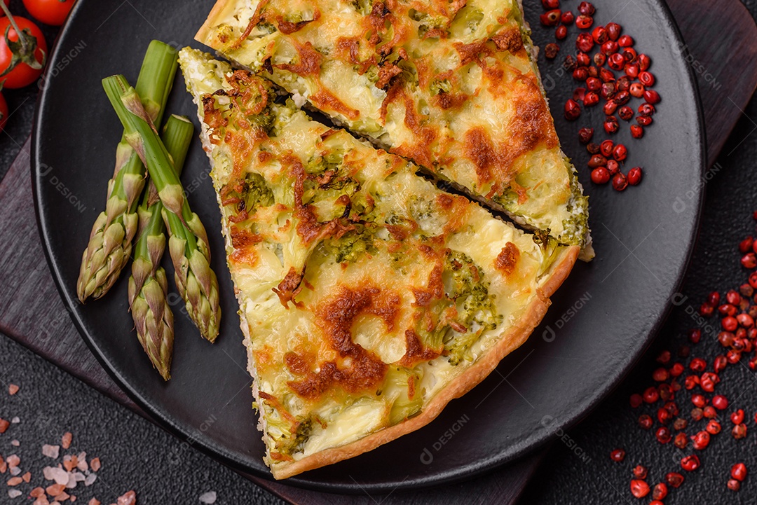 Deliciosa quiche com brócolis, queijo, frango, especiarias e ervas sobre um fundo escuro de concreto