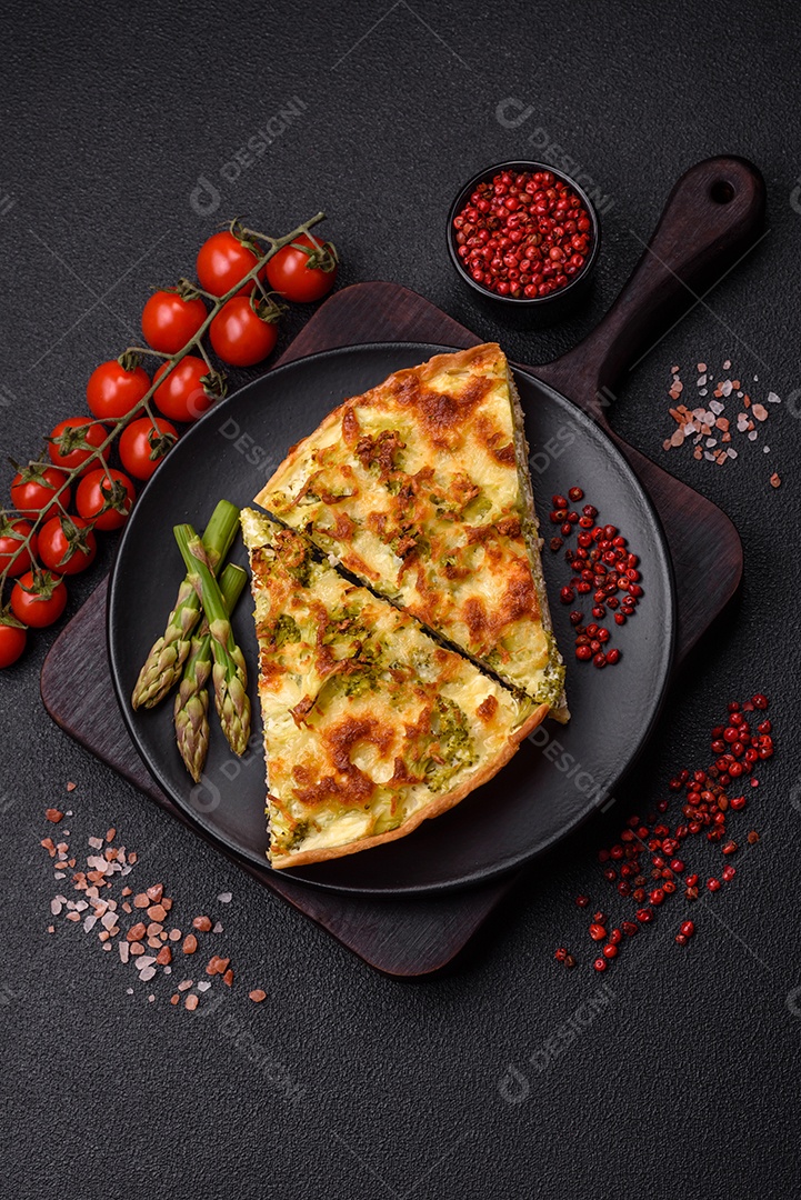 Deliciosa quiche com brócolis, queijo, frango, especiarias e ervas sobre um fundo escuro de concreto