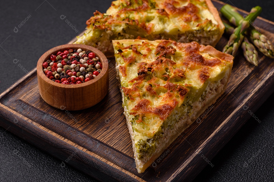 Deliciosa quiche com brócolis, queijo, frango, especiarias e ervas sobre um fundo escuro de concreto