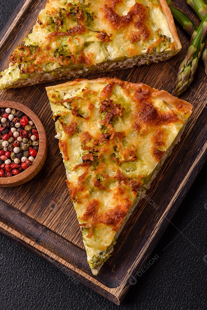Deliciosa quiche com brócolis, queijo, frango, especiarias e ervas sobre um fundo escuro de concreto