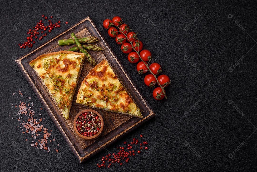 Deliciosa quiche com brócolis, queijo, frango, especiarias e ervas sobre um fundo escuro de concreto