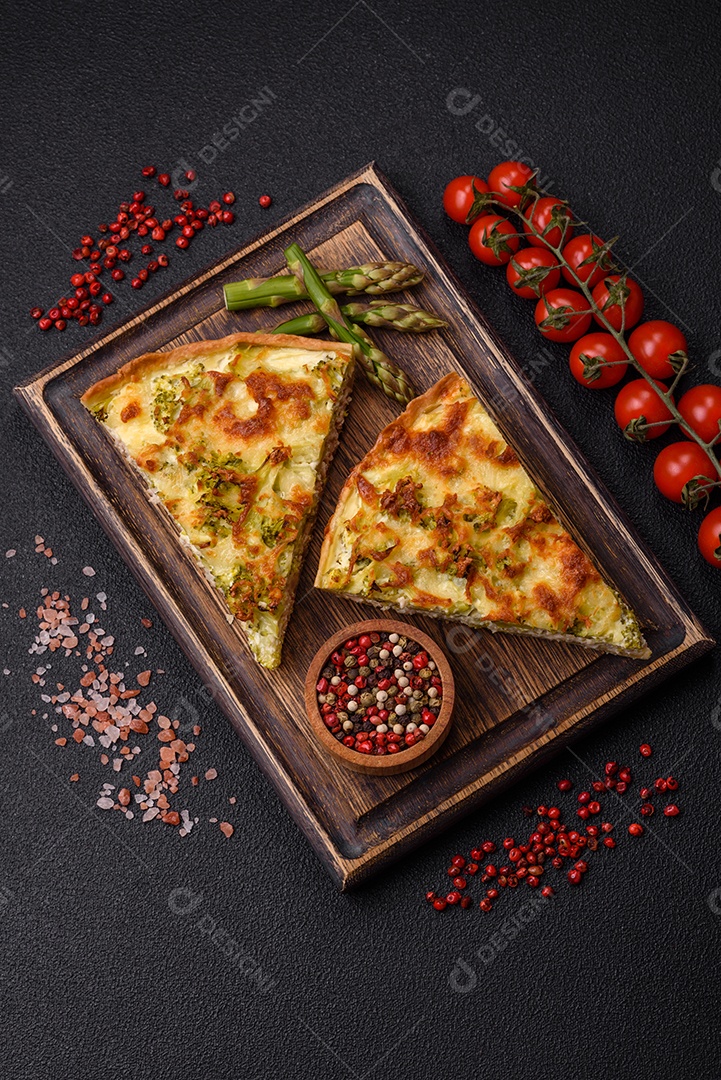 Deliciosa quiche com brócolis, queijo, frango, especiarias e ervas sobre um fundo escuro de concreto