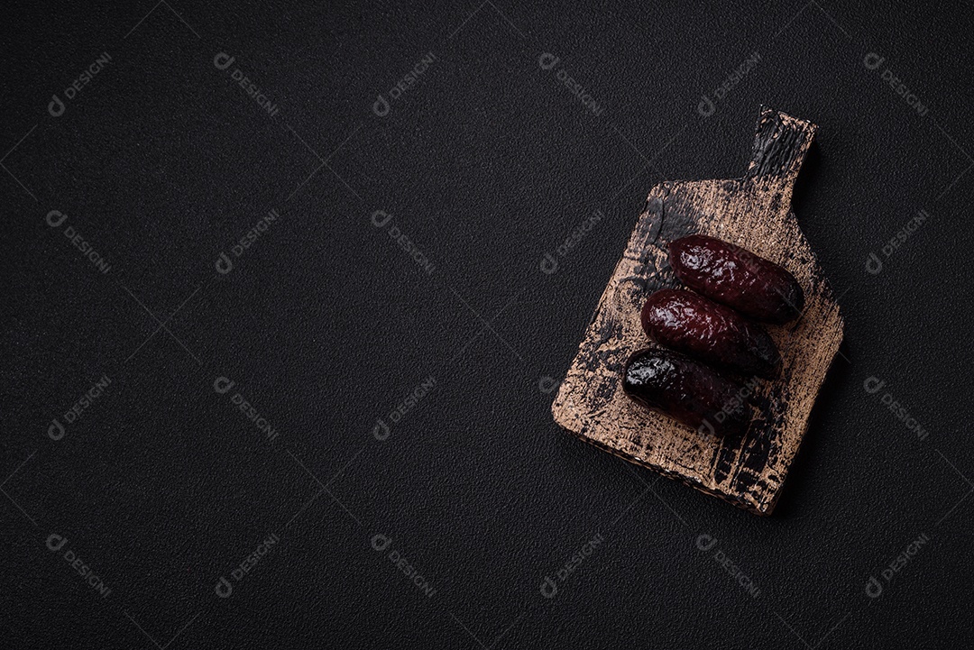 Delicioso chouriço preto ou morcela com especiarias e ervas grelhadas sobre fundo de concreto preto