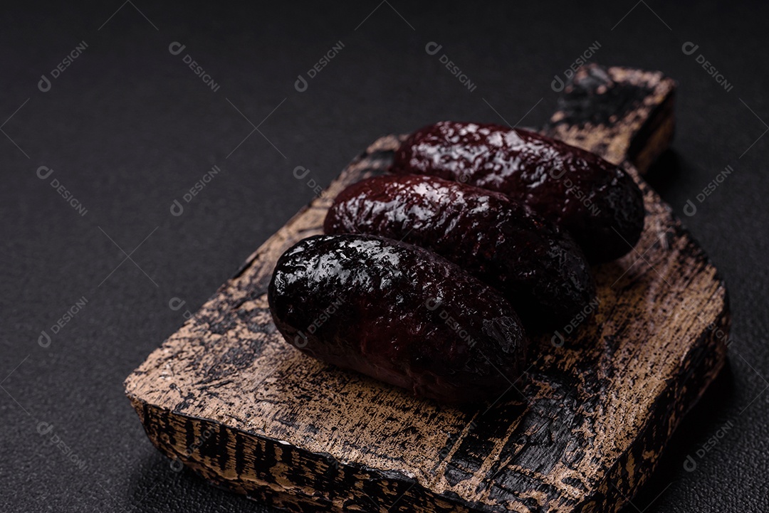 Delicioso chouriço preto ou morcela com especiarias e ervas grelhadas sobre fundo de concreto preto