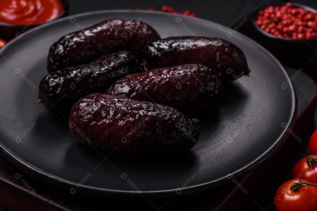 Delicioso chouriço preto ou morcela com especiarias e ervas grelhadas sobre fundo de concreto preto