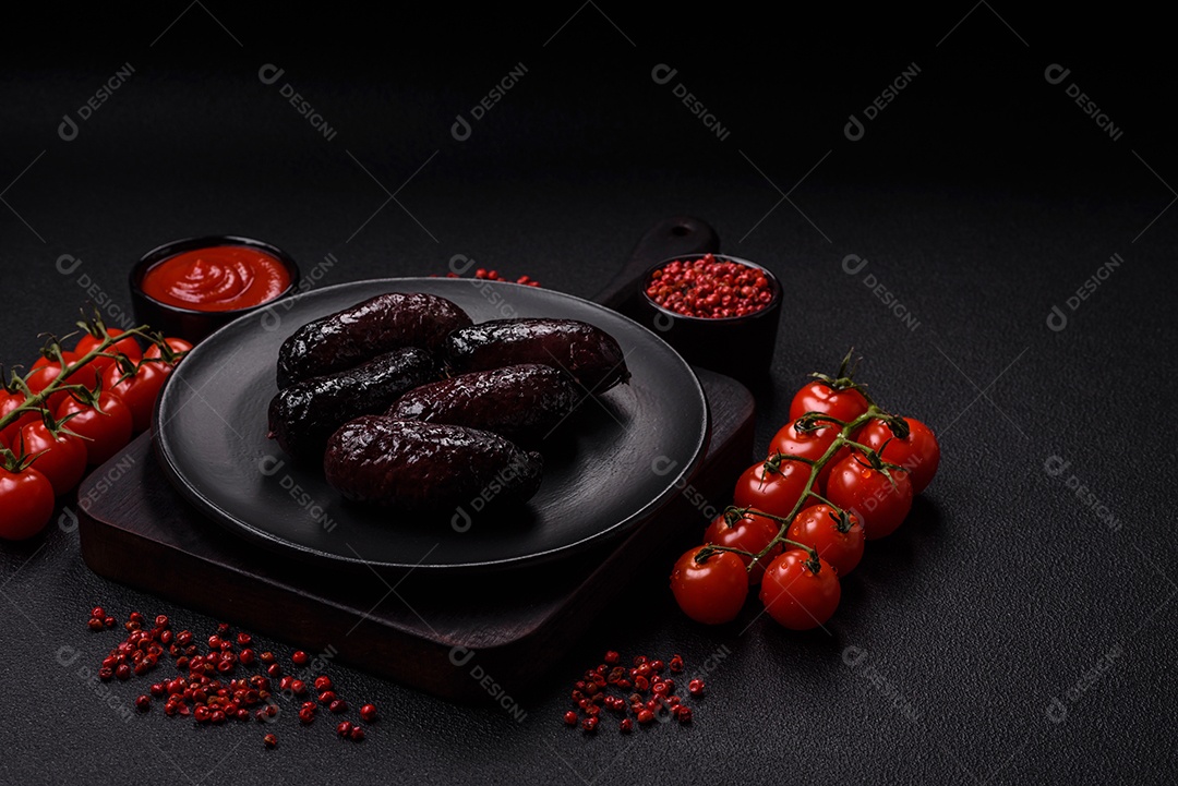 Delicioso chouriço preto ou morcela com especiarias e ervas grelhadas sobre fundo de concreto preto
