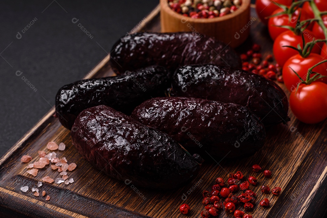 Delicioso chouriço preto ou morcela com especiarias e ervas grelhadas sobre fundo de concreto preto