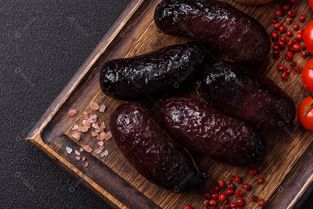 Delicioso chouriço preto ou morcela com especiarias e ervas grelhadas sobre fundo de concreto preto