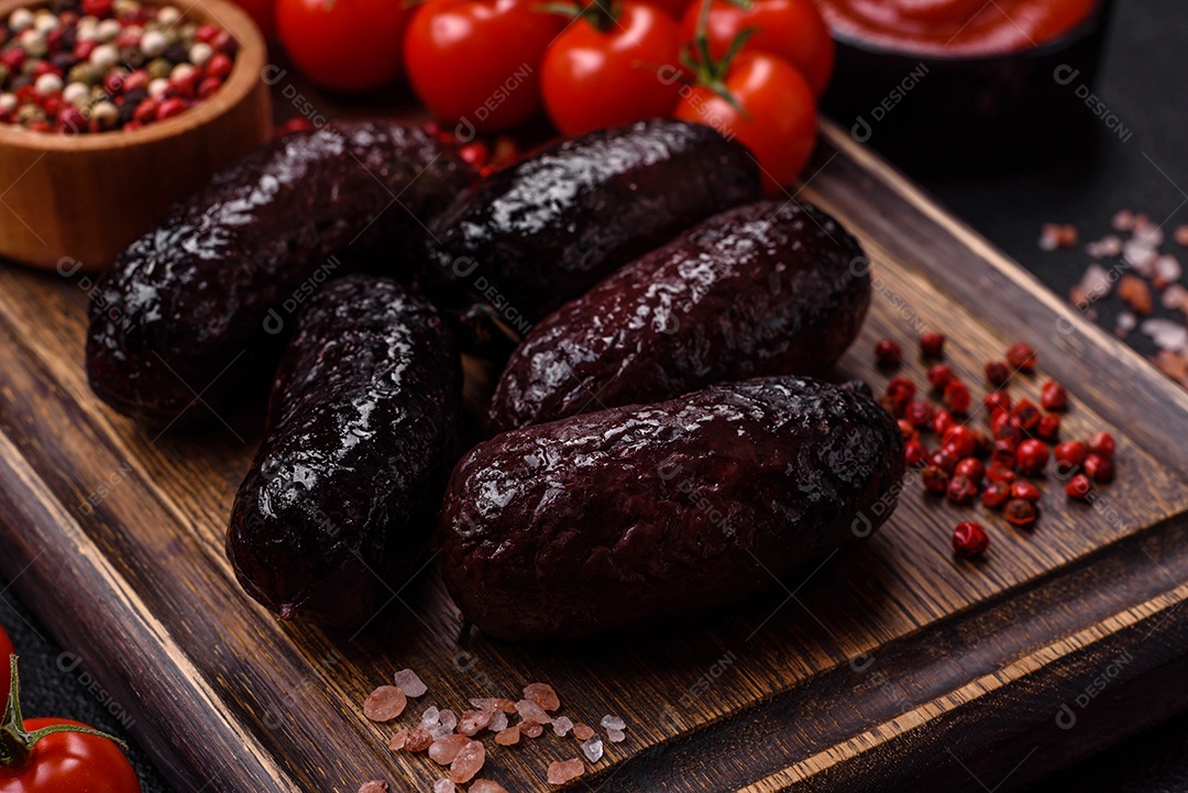 Delicioso chouriço preto ou morcela com especiarias e ervas grelhadas sobre fundo de concreto preto