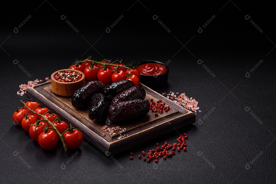 Delicioso chouriço preto ou morcela com especiarias e ervas grelhadas sobre fundo de concreto preto