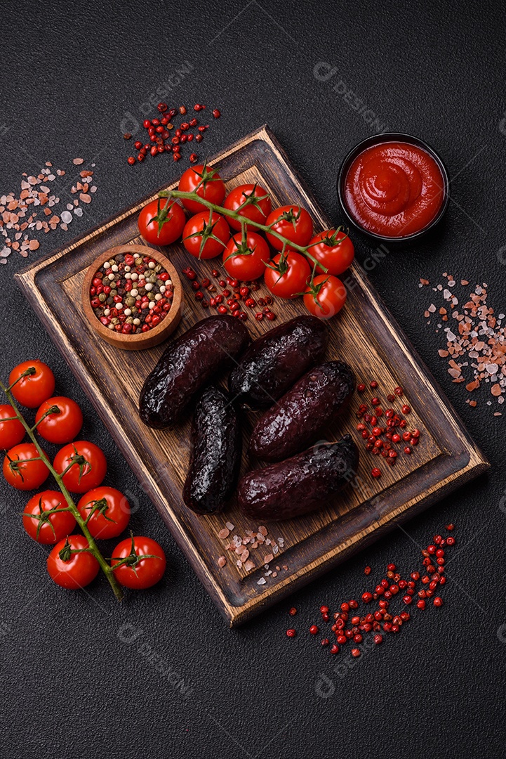 Delicioso chouriço preto ou morcela com especiarias e ervas grelhadas sobre fundo de concreto preto