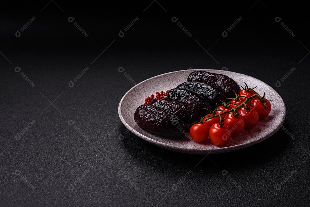 Delicioso chouriço preto ou morcela com especiarias e ervas grelhadas sobre fundo de concreto preto