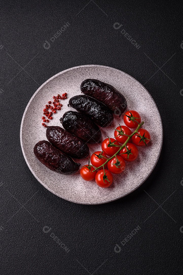 Delicioso chouriço preto ou morcela com especiarias e ervas grelhadas sobre fundo de concreto preto