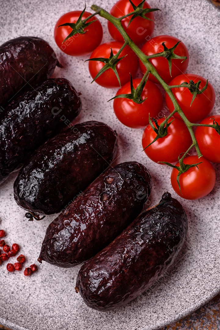 Delicioso chouriço preto ou morcela com especiarias e ervas grelhadas sobre fundo de concreto preto