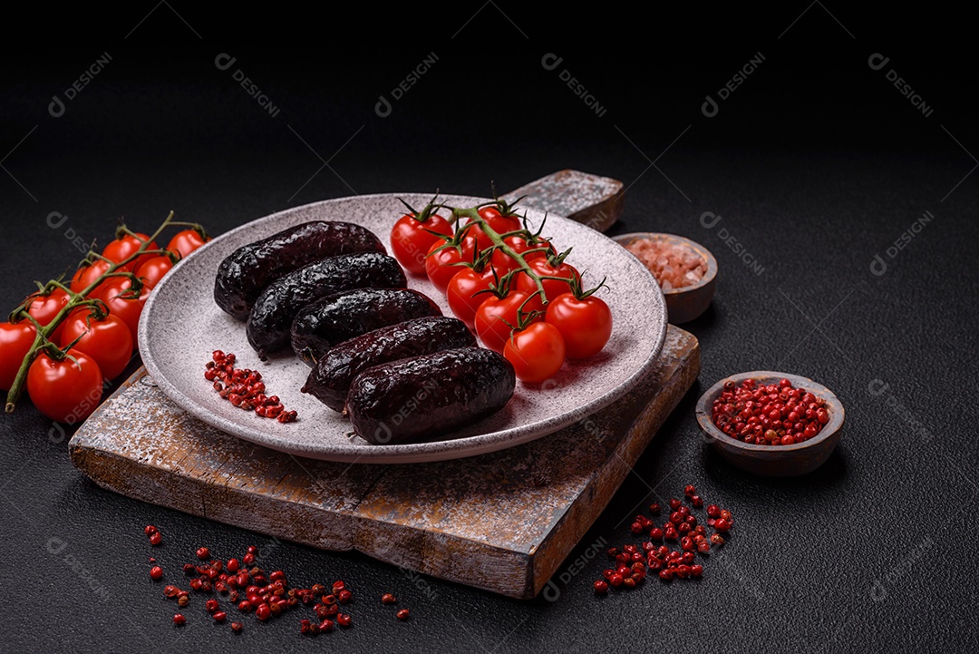 Delicioso chouriço preto ou morcela com especiarias e ervas grelhadas sobre fundo de concreto preto