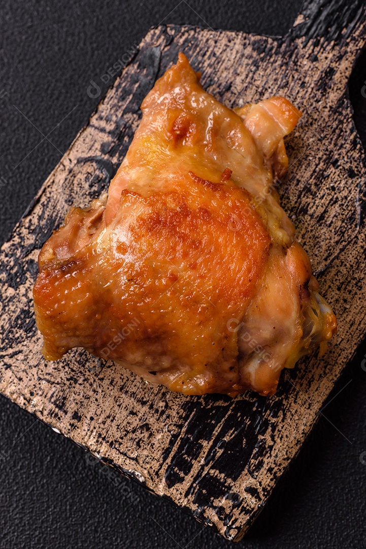 Deliciosas costelas grelhadas suculentas com mel e molho de mostarda com sal, especiarias e ervas sobre um fundo escuro de concreto