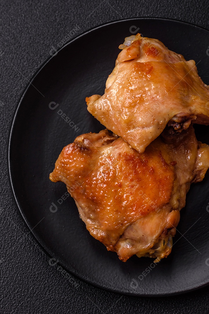 Deliciosas costelas grelhadas suculentas com mel e molho de mostarda com sal, especiarias e ervas sobre um fundo escuro de concreto