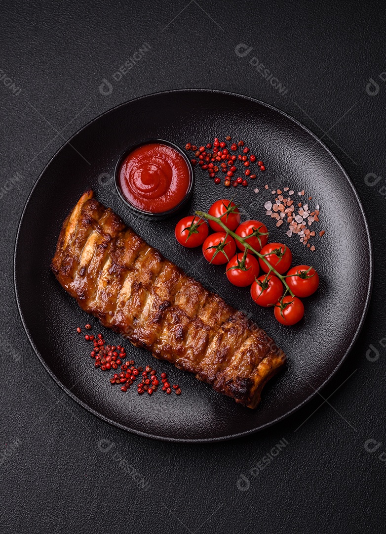 Deliciosas costelas grelhadas suculentas com mel e molho de mostarda com sal, especiarias e ervas sobre um fundo escuro de concreto