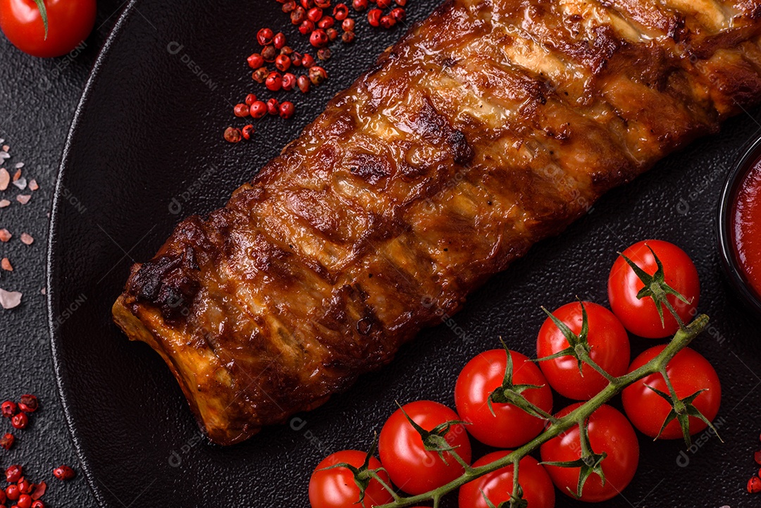 Deliciosas costelas grelhadas suculentas com mel e molho de mostarda com sal, especiarias e ervas sobre um fundo escuro de concreto