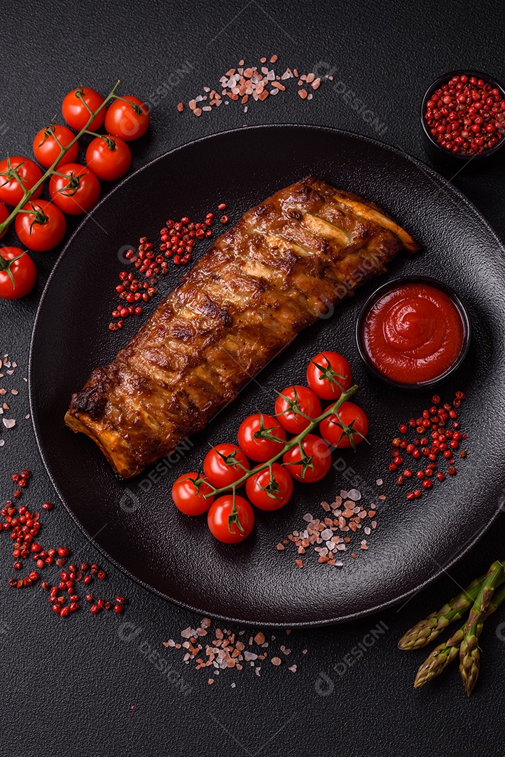 Deliciosas costelas grelhadas suculentas com mel e molho de mostarda com sal, especiarias e ervas sobre um fundo escuro de concreto