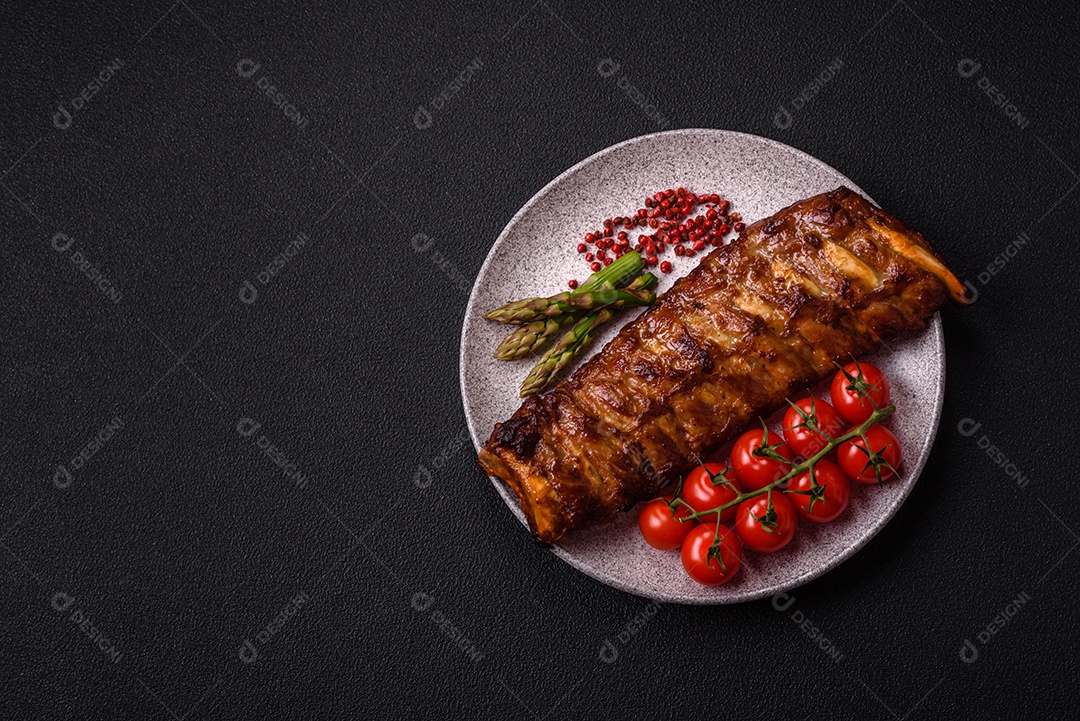 Deliciosas costelas grelhadas suculentas com mel e molho de mostarda com sal, especiarias e ervas sobre um fundo escuro de concreto