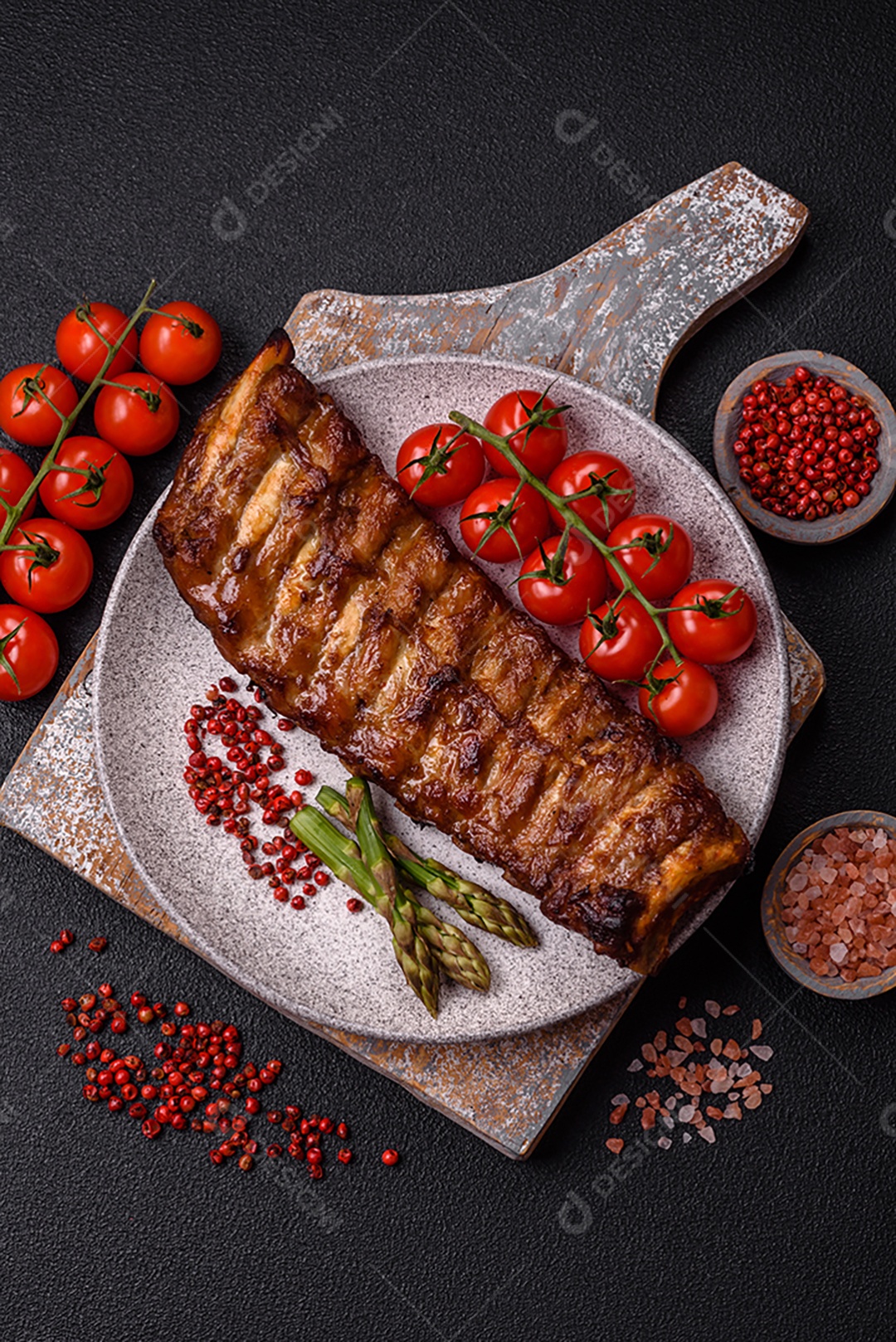Deliciosas costelas grelhadas suculentas com mel e molho de mostarda com sal, especiarias e ervas sobre um fundo escuro de concreto