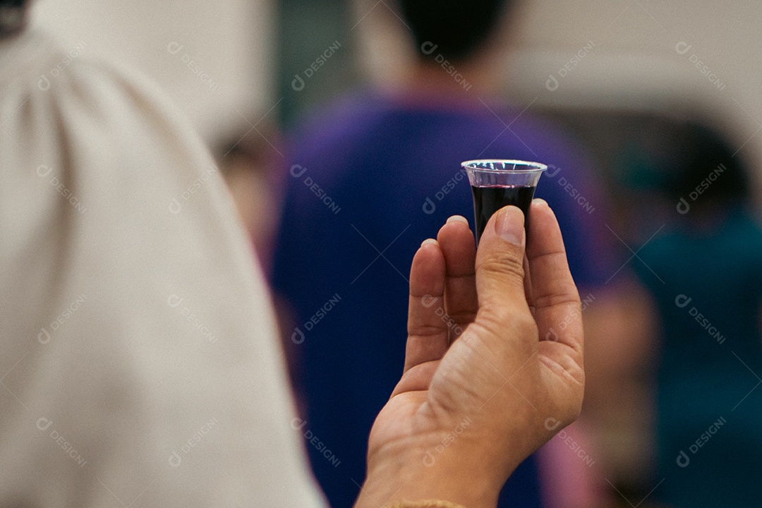 Mão de uma pessoa com pão e vinho para santa ceia