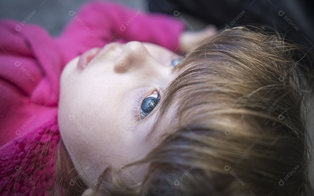 Linda garotinha loira olhando para o céu acima