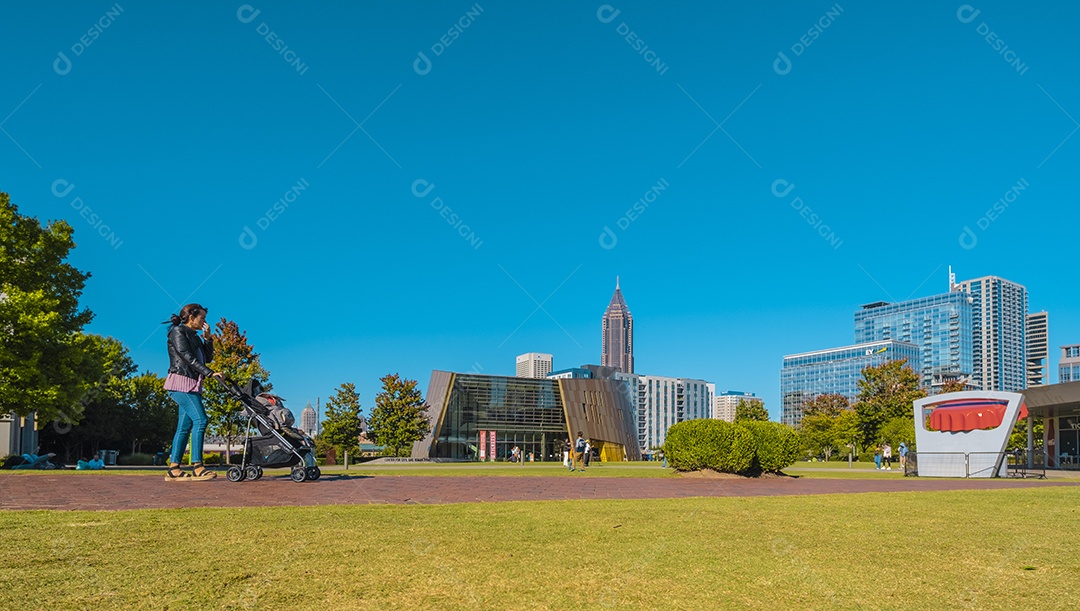 Uma mulher passeando com seu bebê na praça