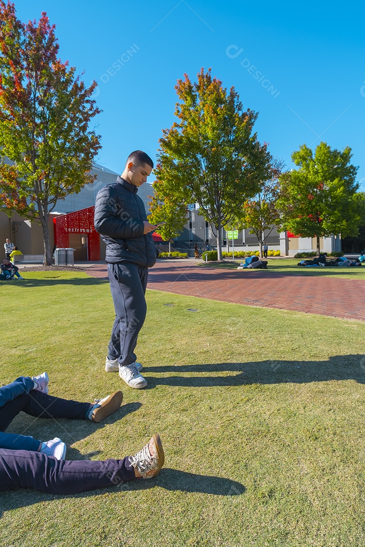 Jovem no parque segurando o celular no verão