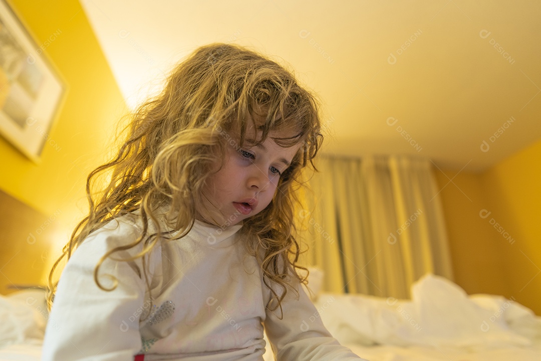 Menina loira olhando para o celular abaixo