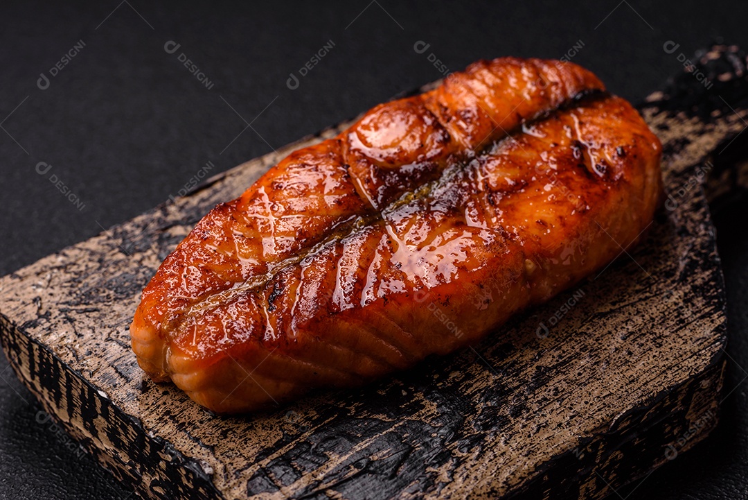 Bife de salmão delicioso cozido fresco com especiarias e ervas assadas em uma grelha. Comida saudável de frutos do mar