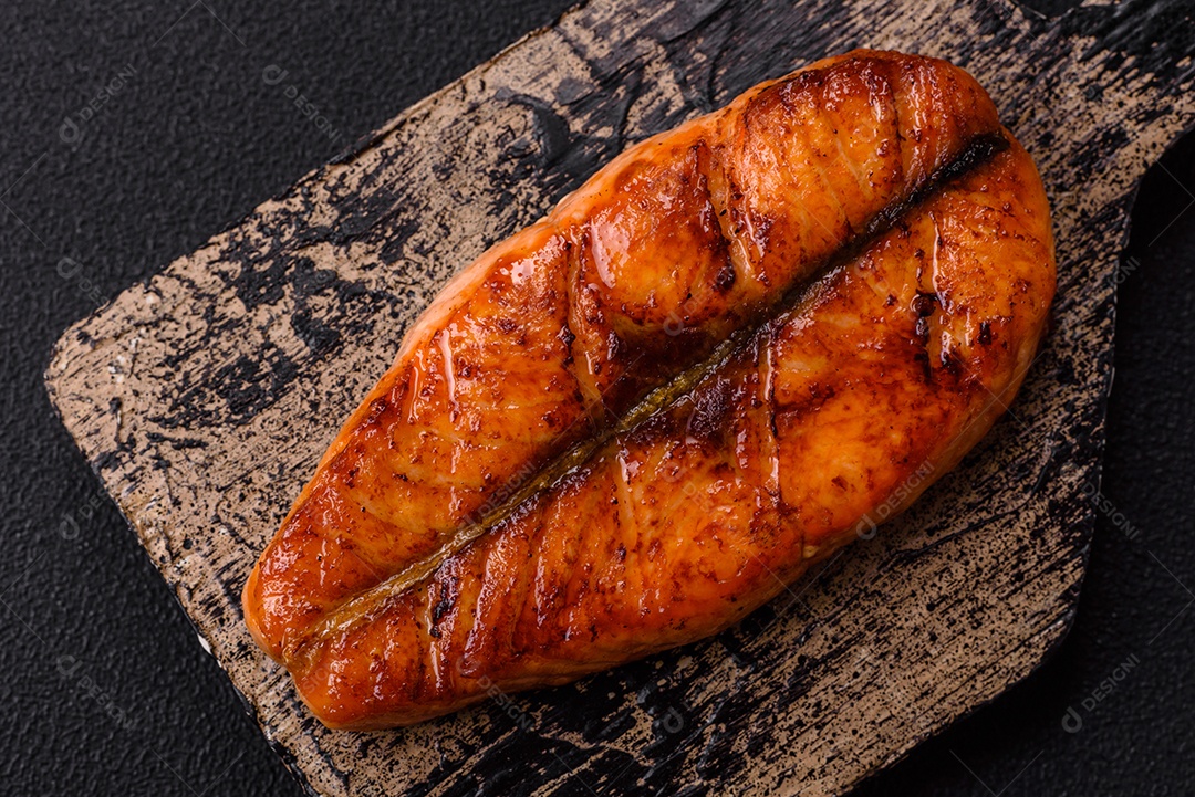 Bife de salmão delicioso cozido fresco com especiarias e ervas assadas em uma grelha. Comida saudável de frutos do mar