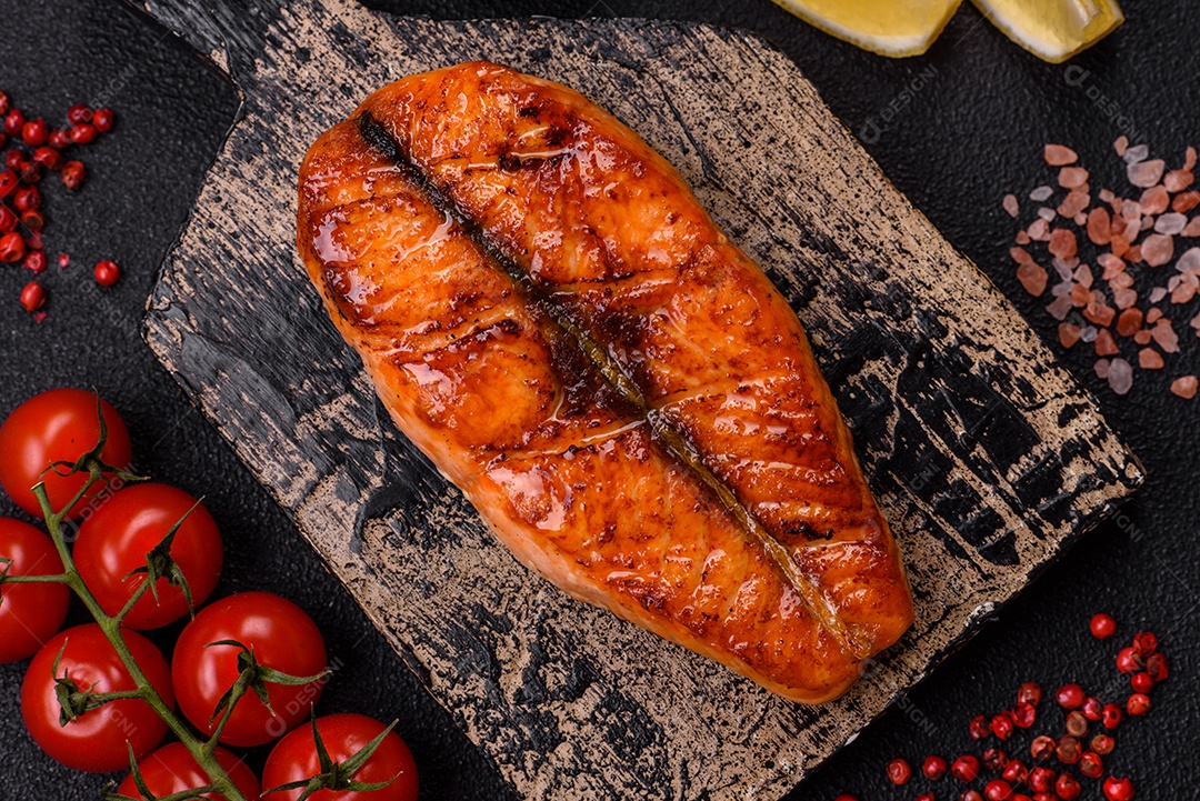 Bife de salmão delicioso cozido fresco com especiarias e ervas assadas em uma grelha. Comida saudável de frutos do mar