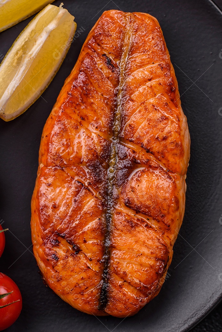 Bife de salmão delicioso cozido fresco com especiarias e ervas assadas em uma grelha. Comida saudável de frutos do mar