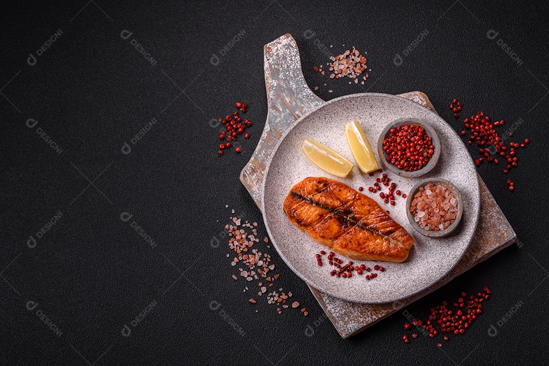 Bife de salmão delicioso cozido fresco com especiarias e ervas assadas em uma grelha. Comida saudável de frutos do mar